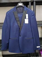 Front view of the men's blue Calvin Klein blazer jacket showing black satin lapels and single button closure.