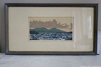 Full view of the framed lithograph print depicting the ocean sunset with blue frame and white mat