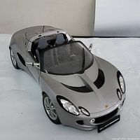 Front and side view of the silver Lotus Elise 111S model car showing the windshield, headlights, and detailed exterior bodywork.