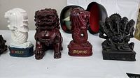 Main grouping showing statues of Singapore Merlion, Foo Dog lion, Naga, and Ganesha figurine arranged on table