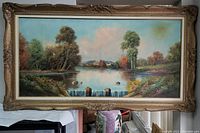 Full view of the framed oil on canvas painting showing a waterfall, river, trees, and village under a blue sky with clouds.