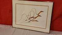 Full view of framed Flying Geese print with white mat and gold border.
