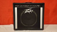 Front view of the Peavey Bandit 75 amplifier showing black tolex exterior, silver vertical stripes on front panel, Peavey logo on speaker grille.
