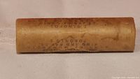 Sealed brown paper roll with printed text indicating contents