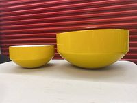 Two yellow Copco bowls, very large (12 inches) and small (8 inches), showing shape and condition.