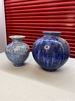 Two vases on white surface showing overall size difference and glaze color variation