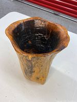 Side angle showing the deep hand carved wooden vase or bowl with natural burled wood patterns and slight cracking.
