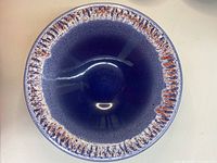 Top view of the large blue pottery bowl showing red/pink textured rim and smooth glossy finish inside.