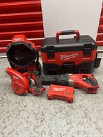Overview showing jobsite fan, Packout toolbox, blower, reciprocating saw, and drill bit case
