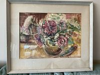 Full view of framed watercolor painting of asters in a glass vase with yellowed matting and white frame exhibiting some discoloration and slight wear.