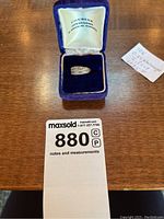 Ring in purple velvet jeweller’s box with note and lot card visible