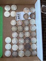 Box containing all 39 Canadian silver dollars laid out