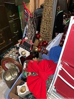 General overview of the lot containing ornaments, a red bow, gift bags, and some trays in a basement environment