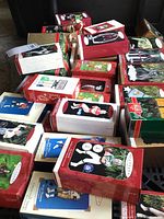 Overview of multiple boxed Hallmark Keepsake ornaments including NFL player figures, glitter ball and Lionel train.