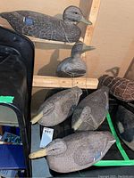 Overall view of five wooden duck decoys arranged on a shelf.