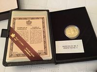 Open presentation case showing certificate and coin.