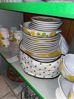 Stack of dinner plates, saucers and zippered bag on shelf