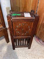 Front view showing wooden mission style case, brass numerals, and winding key on top
