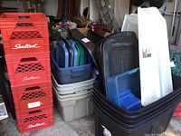 Photo showing part of the stack of four red Sealtest milk crates next to the nested plastic totes and lids.