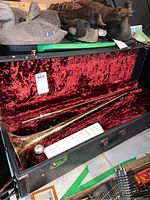 Trombone and slide assembly in open black case with red velvet interior