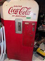 Full front view showing red lower half and white upper half with logo and coin door