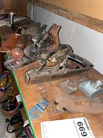 Three vintage metal hand planes on shelf