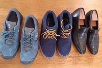 All three pairs of men's shoes: blue Swiss Engineering athletic, navy Sperry casual, black Canali dress shoes with shoe trees.