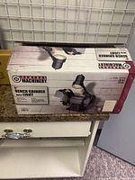 Box of the Central Machinery 6-inch bench grinder with light showing brand and product image.