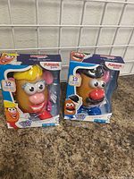 Photo showing new Mr. and Mrs. Potato Head toys in original PlaySkool packaging with 12 and 13 pieces respectively