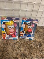 Photo of two new in box Mr. and Mrs. Potato Head toys with visible front packaging and clear windows.