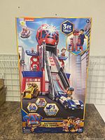 Front of box showing 3ft tall PAW Patrol Ultimate City Tower toy, colorful branding, and characters.