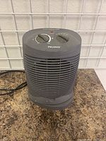 Front view showing control dials and front vent grill with paint splatters visible on surfaces.