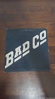 Vinyl record cover with black background and large white 'BAD CO' lettering