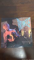 Front cover of David Bowie Lets Dance album with artistic image of Bowie.