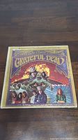 Front cover of The Grateful Dead self-titled album showing colorful psychedelic artwork and band members.