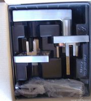 Two satin chrome rectangular lever door handles in original packaging with plastic wrapping and installation components.