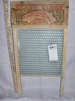 Front view of the washboard showing the glass scrubbing surface and wooden top label with company and product branding