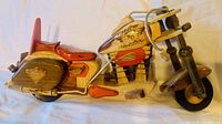 Side view of hand carved wooden Harley Davidson motorcycle showing details of paint and movable parts