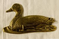 Front view of vintage solid brass goose coat hook showing detailed feather engraving and two small hooks for hanging items.