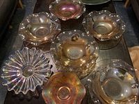 Top view of all carnival glass bowls and one plate on table showing matching lotus pattern and color variations (amber and clear)