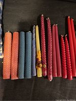 Assorted twisted beeswax candles in orange, blue, purple, yellow, red and pink, all unlit