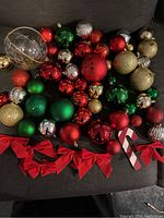 Top view of assorted Christmas ornaments showing red, green, gold, silver baubles and red bows