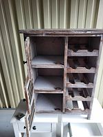 Open cabinet showing bottle rack on right side and two shelving compartments on left side