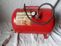 Front view of red cylindrical Craftsman air tank with label and pressure gauge showing hose attached.