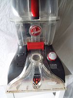 Front view of the Hoover FH50252 rug cleaner showing clear water tank, control dial, handle, and HeatForce indicator.