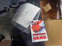 Marlboro Unlimited Gear tag and instruction sheet in plastic packaging, resting on the poker table top bag.