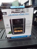 Front and part of the side of the PowerXL Air Fryer Home Pro box showing brand, product image and features such as 12QT capacity and 6-in-1 cooking functions.