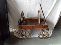 Side view of the complete wooden wagon with attached wheels and handle.