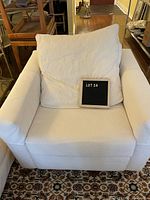 Front view with loose back cushion and wide arms on patterned rug