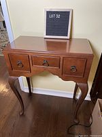 Full view of wooden telephone table showing Queen Anne cabriole legs and three drawers with ring pull handles.